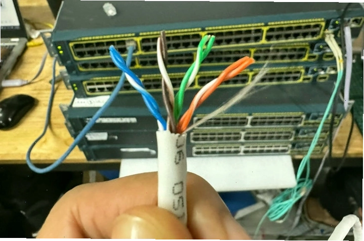 Cận cảnh thao tác tuốt bỏ lớp vỏ ngoài của dây cáp mạng để lộ 8 sợi dây đồng xoắn