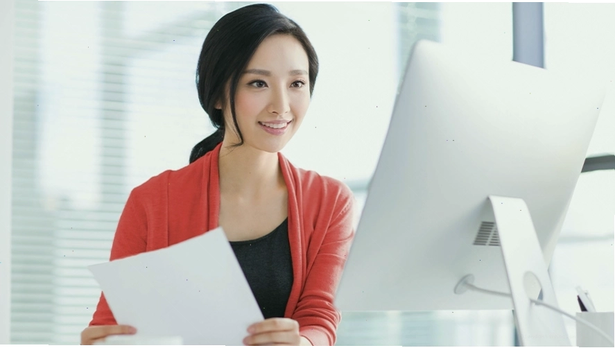 Người phụ nữ làm việc tại văn phòng, có thể liên quan đến việc chuẩn bị hồ sơ mở thẻ