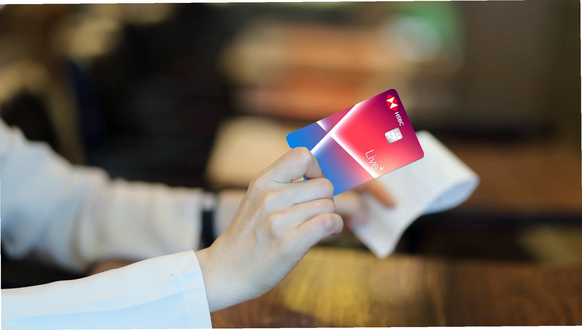 Người phụ nữ sử dụng thẻ tín dụng để thanh toán tại cửa hàng