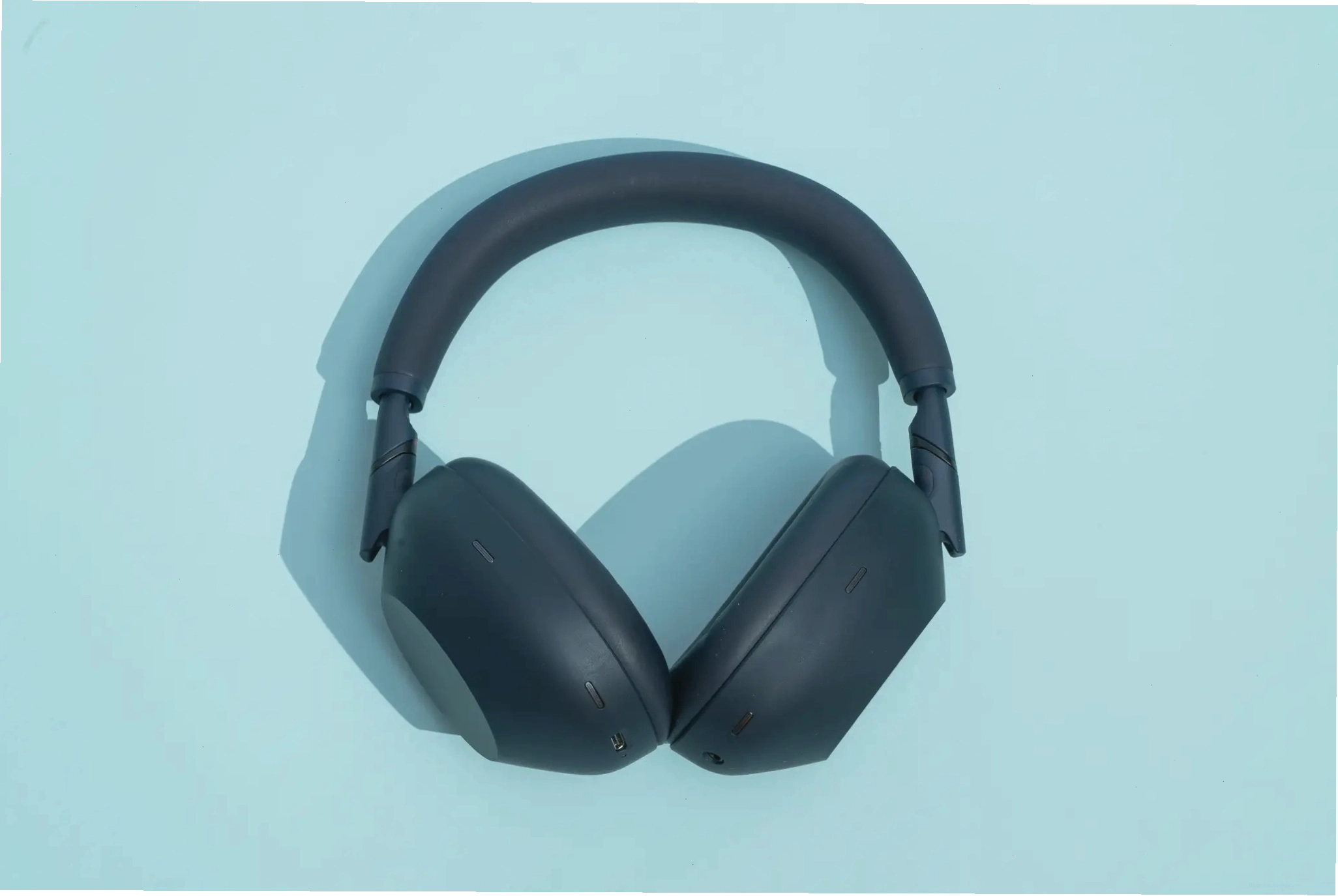 Tai nghe Sony WH-1000XM6 đặt trên nền xanh, minh họa khả năng chống ồn